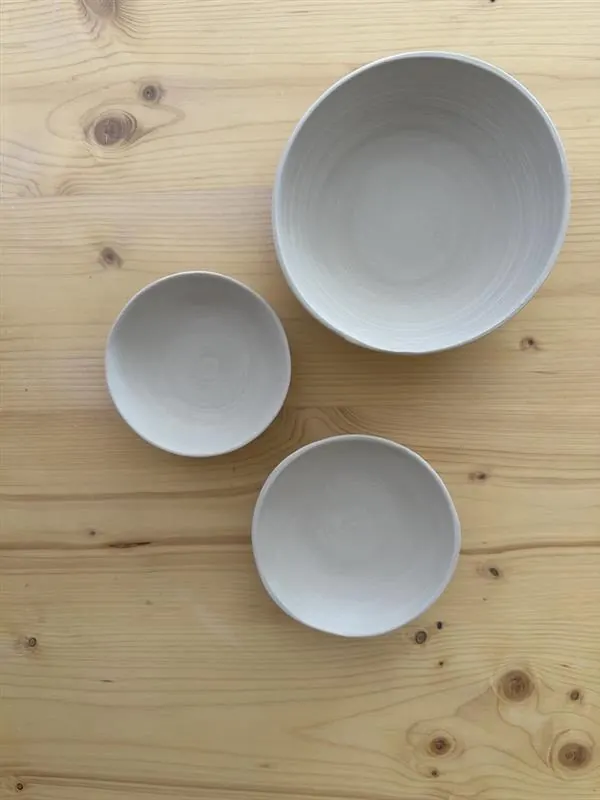 Drei weisse Schalen von oben auf dem Arbeitstisch.